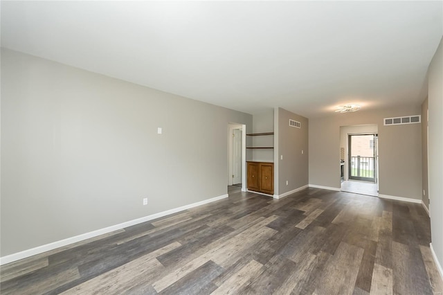 unfurnished living room with baseboards, dark wood-style floors, and visible vents