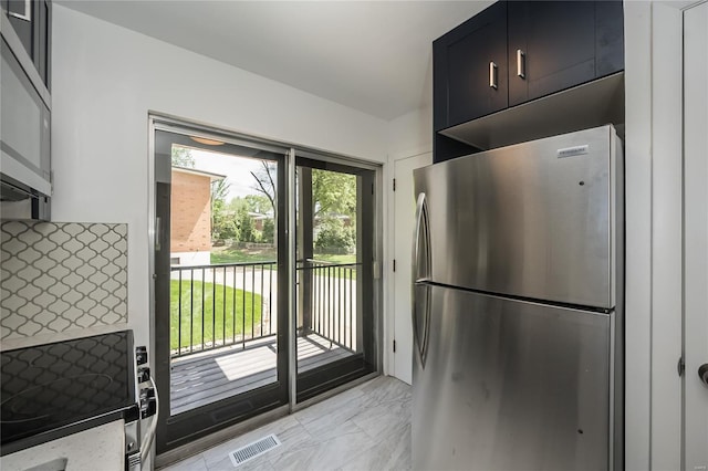 kitchen featuring freestanding refrigerator, light stone countertops, visible vents, and marble finish floor