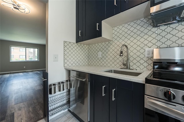 kitchen with stainless steel electric range oven, light stone counters, a sink, dark cabinetry, and decorative backsplash