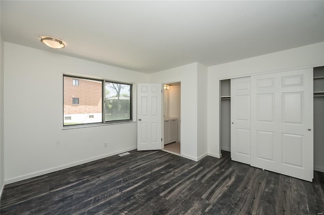 unfurnished bedroom featuring dark wood-style flooring, baseboards, and a closet