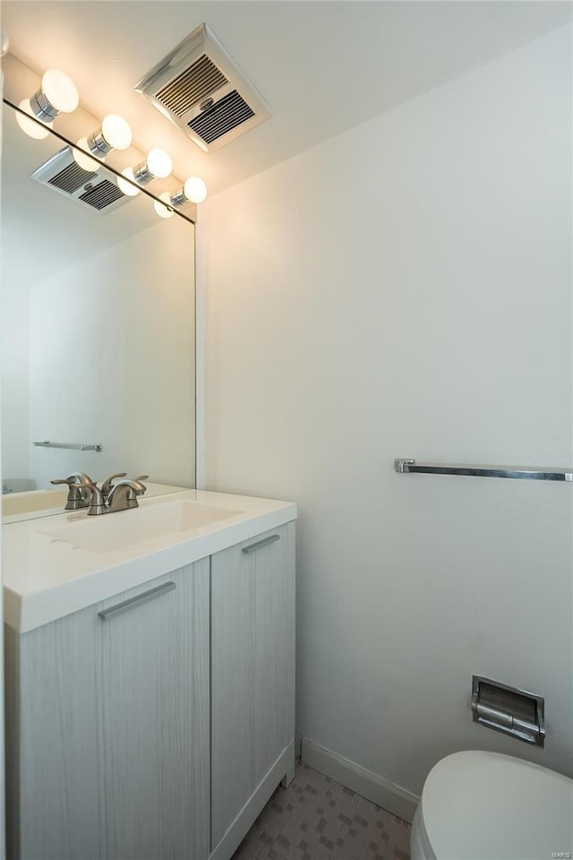 bathroom with visible vents, baseboards, toilet, and vanity