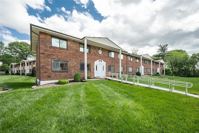 multi unit property with brick siding, fence, and a front yard