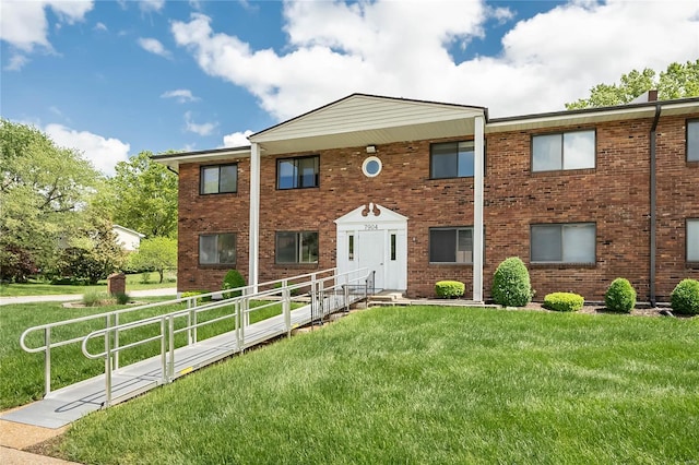 view of front of home with brick siding and a front yard