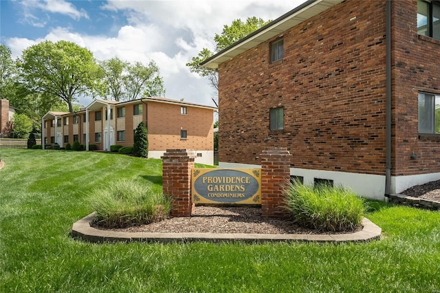 community / neighborhood sign featuring a yard
