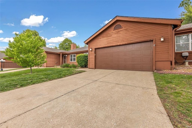 view of front facade with concrete driveway, an attached garage, a chimney, and a front lawn