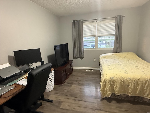 bedroom with baseboards, visible vents, a textured ceiling, and dark wood-type flooring