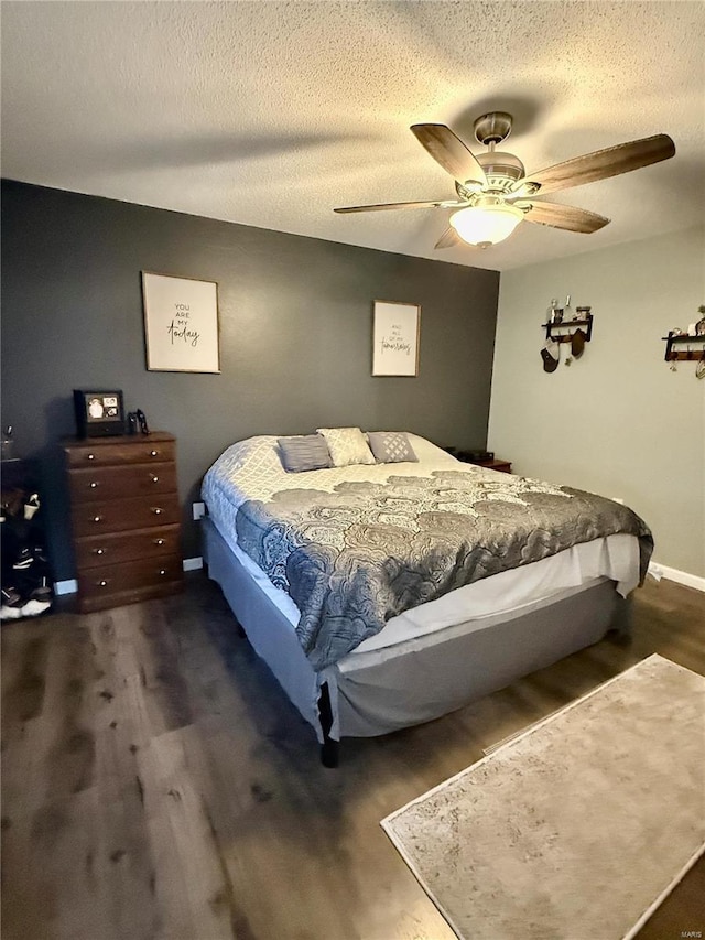 bedroom featuring a textured ceiling, a ceiling fan, and wood finished floors