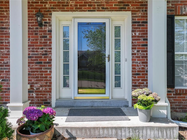 view of exterior entry with brick siding