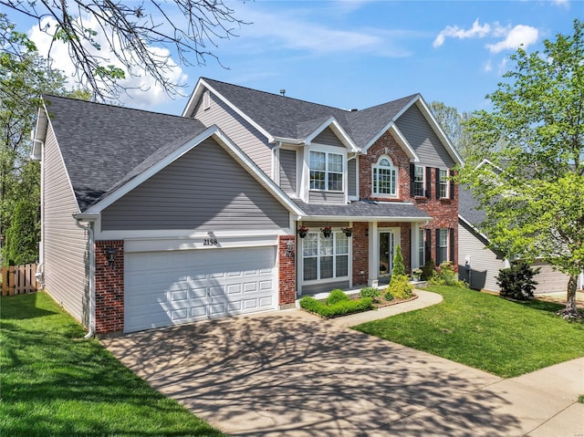 traditional-style house featuring brick siding, an attached garage, driveway, and a front yard