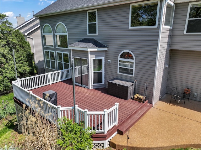 rear view of house with a deck and roof with shingles
