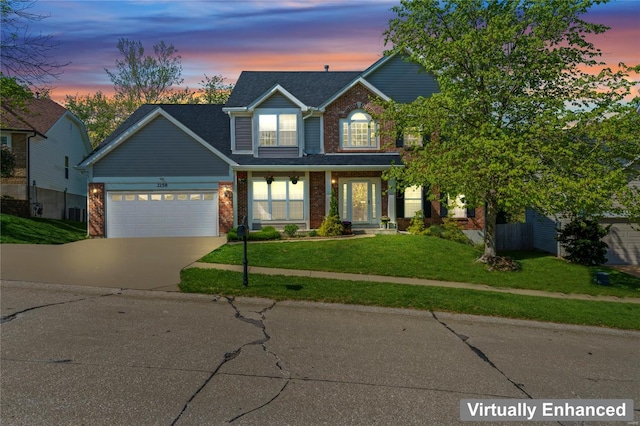 traditional home with an attached garage, a front lawn, brick siding, and concrete driveway