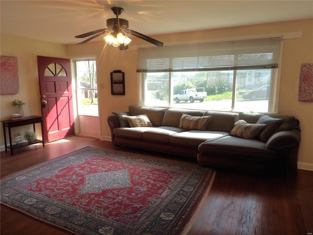 living area featuring baseboards, a ceiling fan, and hardwood / wood-style flooring