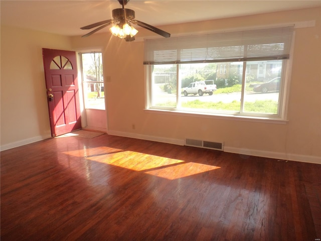 spare room with baseboards, a ceiling fan, wood finished floors, and visible vents