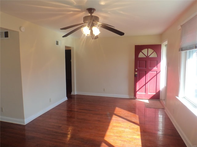 spare room with baseboards, ceiling fan, visible vents, and wood finished floors