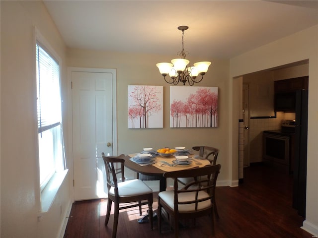 dining room featuring dark wood-type flooring, baseboards, and a notable chandelier