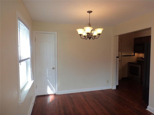 unfurnished dining area with an inviting chandelier, dark wood-style flooring, and baseboards