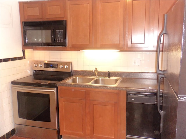 kitchen with a sink, backsplash, black appliances, and dark countertops
