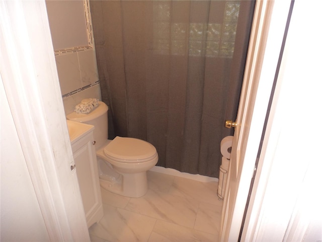 bathroom featuring vanity, toilet, curtained shower, and marble finish floor