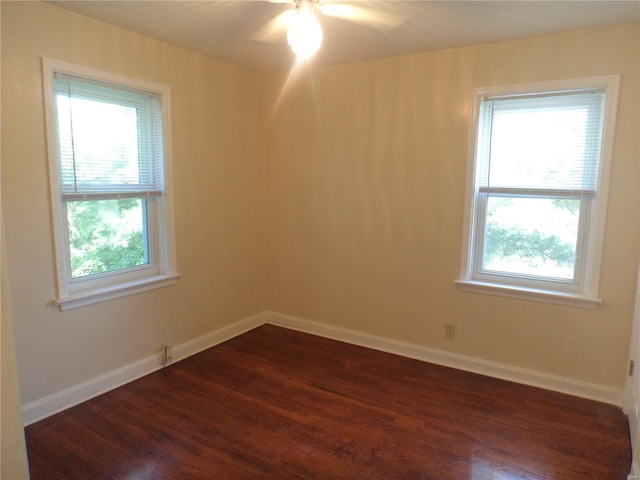 unfurnished room with baseboards, a ceiling fan, a wealth of natural light, and dark wood-style floors