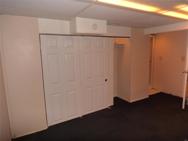unfurnished bedroom with dark carpet and a closet