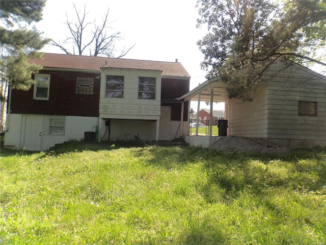 back of property featuring central air condition unit and a yard