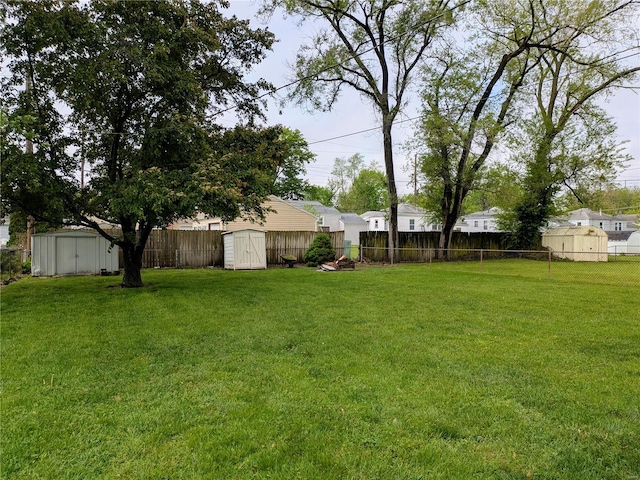 view of yard with a fenced backyard, a storage unit, and an outdoor structure
