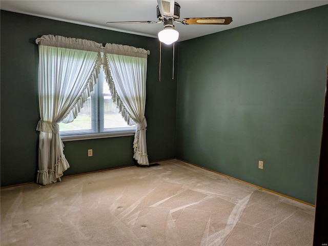 carpeted spare room with baseboards and ceiling fan