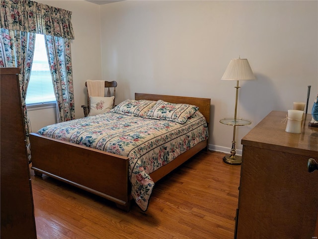 bedroom with baseboards and wood finished floors