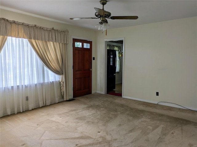 carpeted entryway with a ceiling fan and baseboards