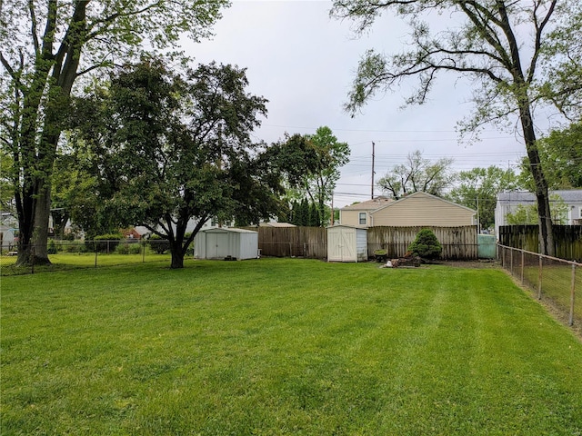 view of yard with a fenced backyard, an outbuilding, and a storage shed