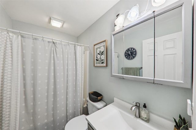 full bathroom featuring toilet, curtained shower, and vanity