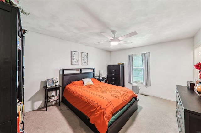 bedroom with a ceiling fan, baseboards, and light carpet
