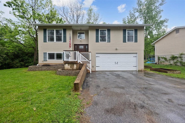 bi-level home featuring an attached garage, a front lawn, and aphalt driveway