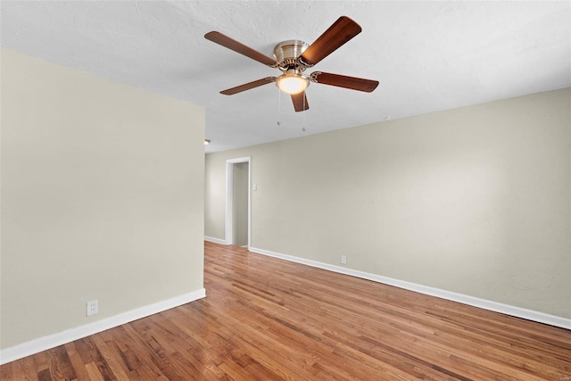 unfurnished room featuring baseboards, a ceiling fan, and light wood finished floors