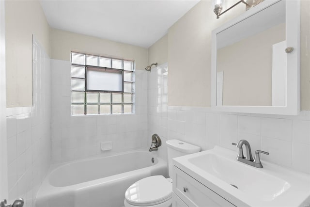 bathroom with vanity, shower / bathing tub combination, toilet, and tile walls