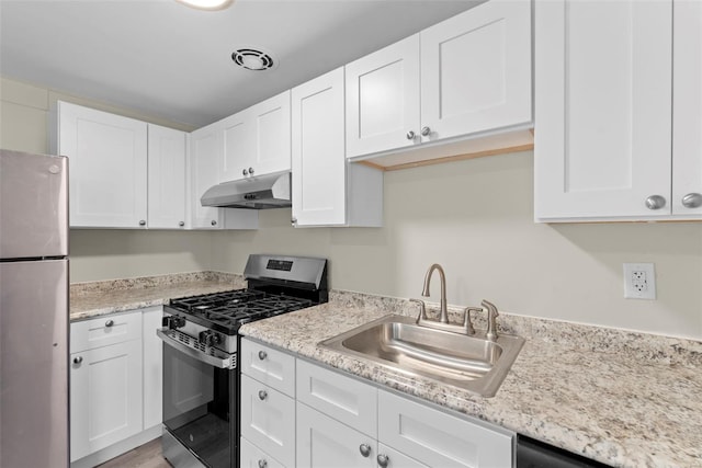 kitchen featuring under cabinet range hood, white cabinetry, appliances with stainless steel finishes, and a sink