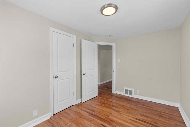 unfurnished bedroom with baseboards, visible vents, and light wood-style floors