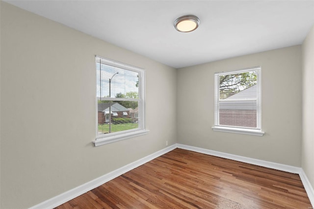 unfurnished room featuring baseboards and wood finished floors
