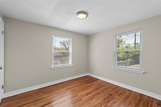 empty room featuring baseboards and wood finished floors