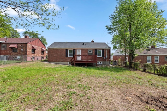 back of property with brick siding, a fenced backyard, and a yard