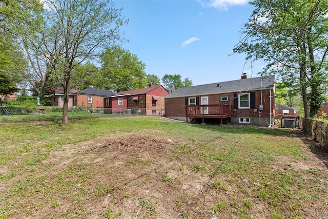 back of property with a wooden deck, central air condition unit, brick siding, a fenced backyard, and a yard