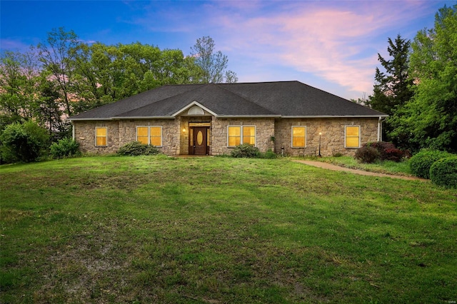 single story home featuring a front yard and stone siding