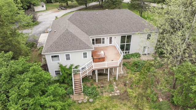 back of property featuring roof with shingles, a wooden deck, an outdoor structure, a storage unit, and stairs