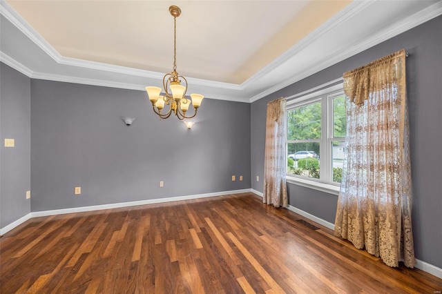 unfurnished room with an inviting chandelier, ornamental molding, visible vents, wood finished floors, and baseboards