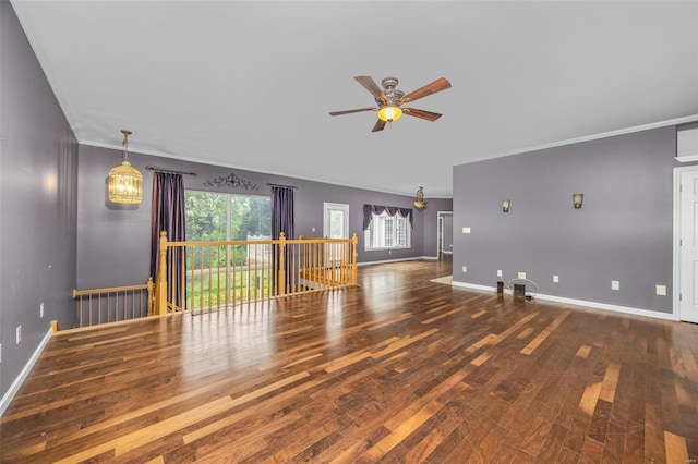 unfurnished living room featuring baseboards, ornamental molding, a ceiling fan, and wood finished floors