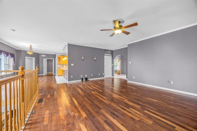 unfurnished living room featuring arched walkways, ceiling fan, hardwood / wood-style floors, and a wealth of natural light