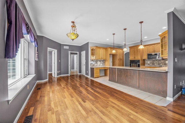 kitchen with backsplash, light countertops, stainless steel microwave, glass insert cabinets, and black oven