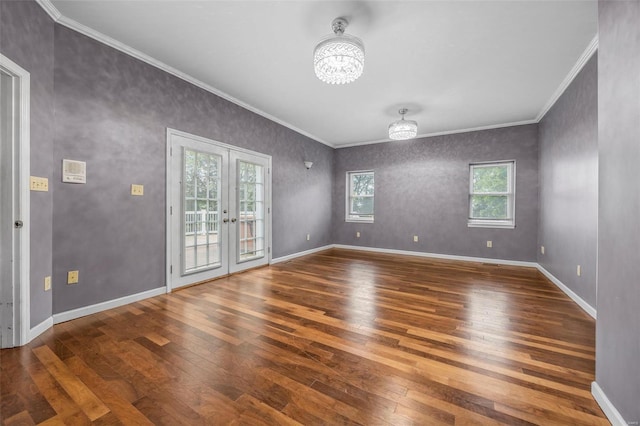 empty room featuring crown molding, baseboards, wood-type flooring, and french doors