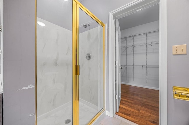 bathroom featuring a marble finish shower and baseboards