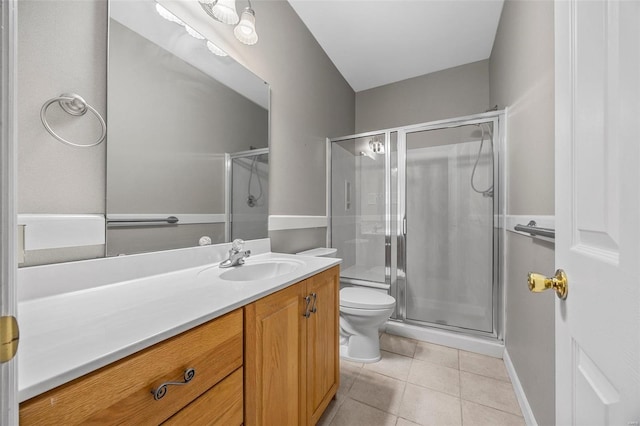 full bathroom with tile patterned flooring, a stall shower, vanity, baseboards, and toilet